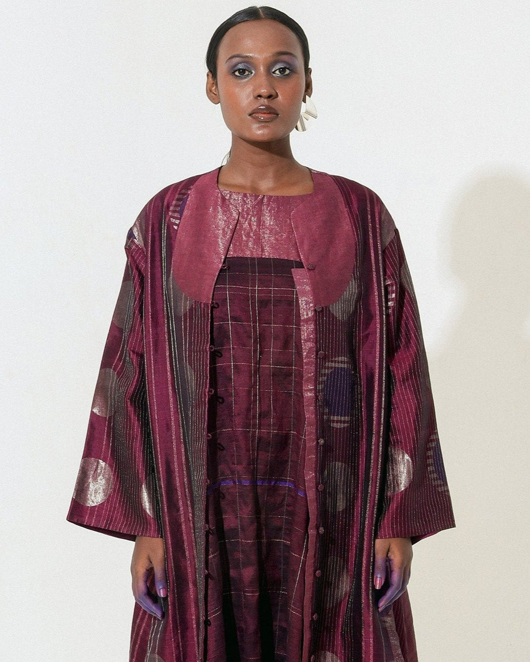 The Shoonyata Multiple Circle Jacket Dress is crafted from handwoven silk using the traditional Jacquard Jamdani technique, The jacket features an open-front design with three-quarter-length sleeves.