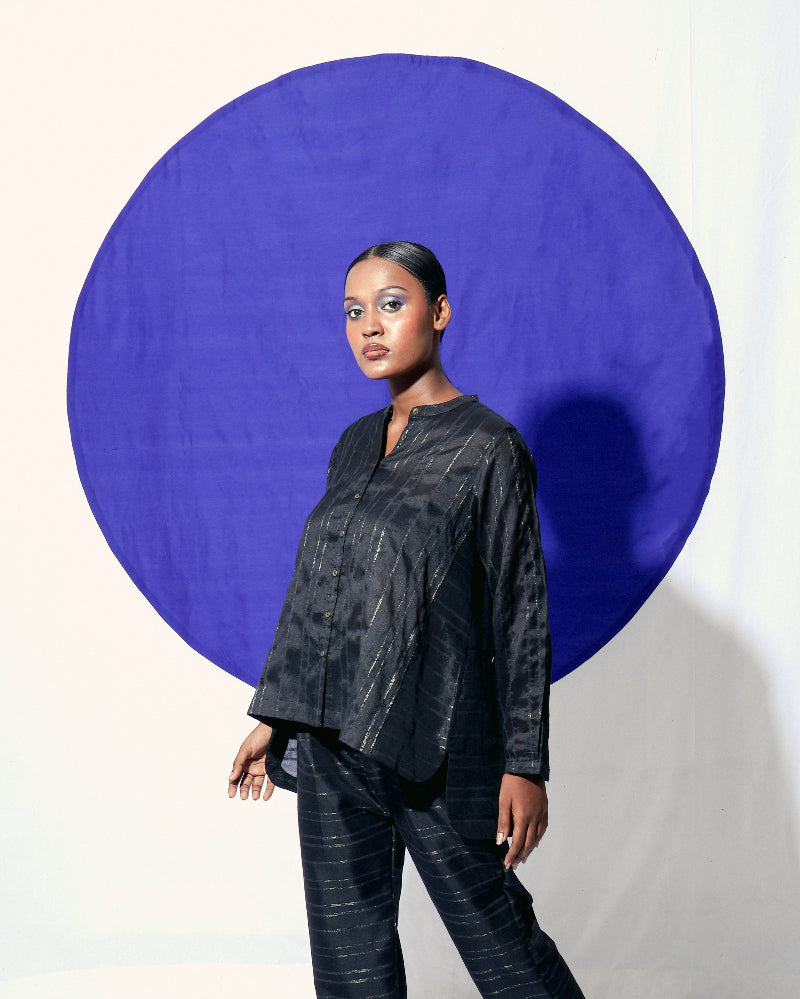 The Shoonyata Burnished Stripe Straight Pants is crafted from silk fabric. The straight-cut pants feature a relaxed silhouette, merging comfort with a refined style. The rich black shade, combined with the burnished sheen of the zari stripes.