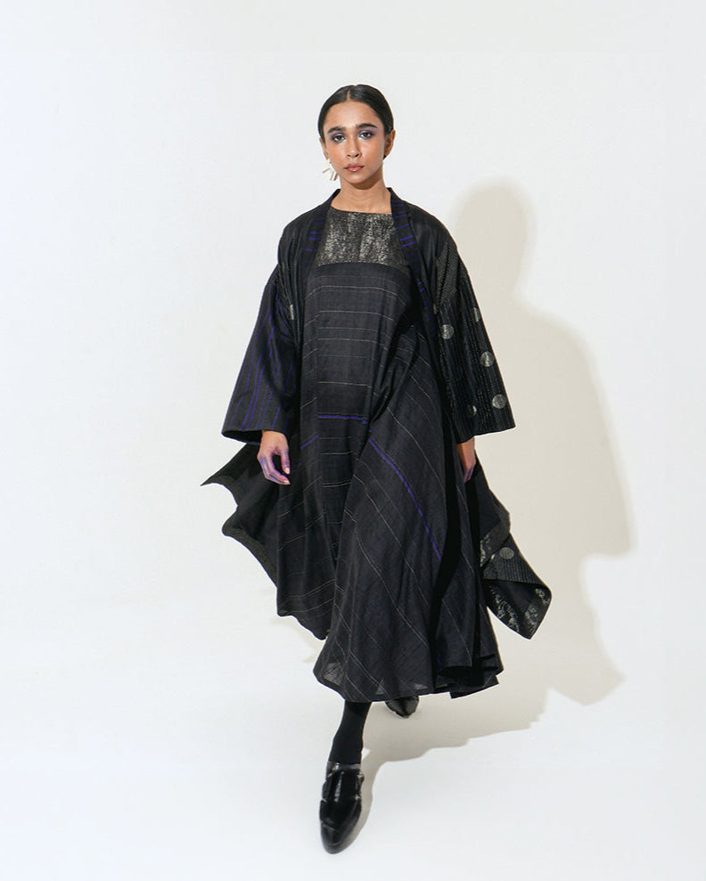 The Shoonyata Lunar Dress is a sleeveless garment with a relaxed silhouette that flows elegantly Made from handwoven silk using the traditional weaving technique.