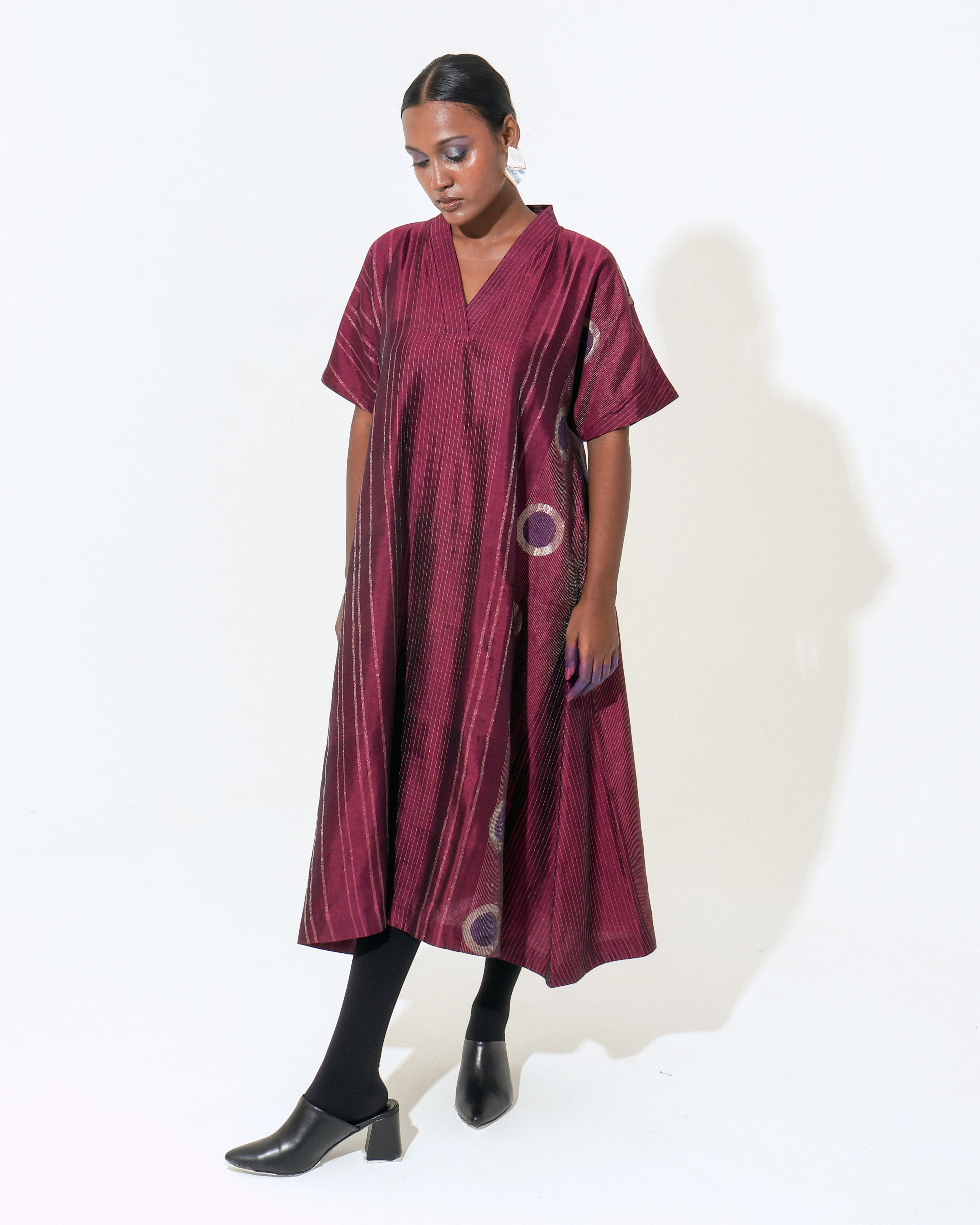 The Shoonyata Neelbindu Dress is crafted from handwoven silk, featuring the intricate Jacquard Jamdani technique with circular motifs across the fabric. Designed with a relaxed A-line silhouette that flows to a midi length, this dress exudes elegance and comfort.