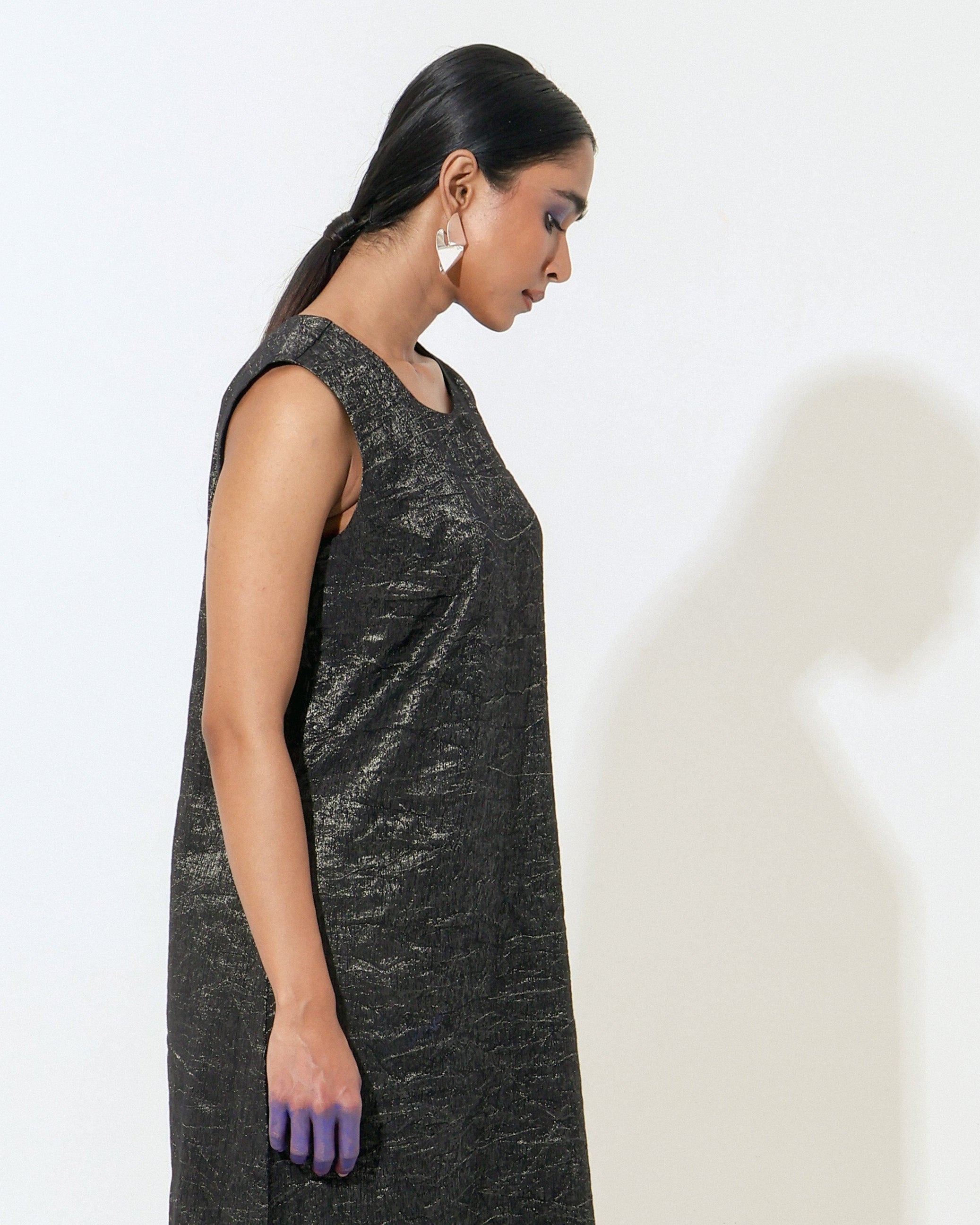 The Shoonyata Burnished Sleeveless Dress is crafted from handwoven silk. .The sleek A-line cut gently skims the body, while the sleeveless design and soft round neckline enhance its modern appeal.