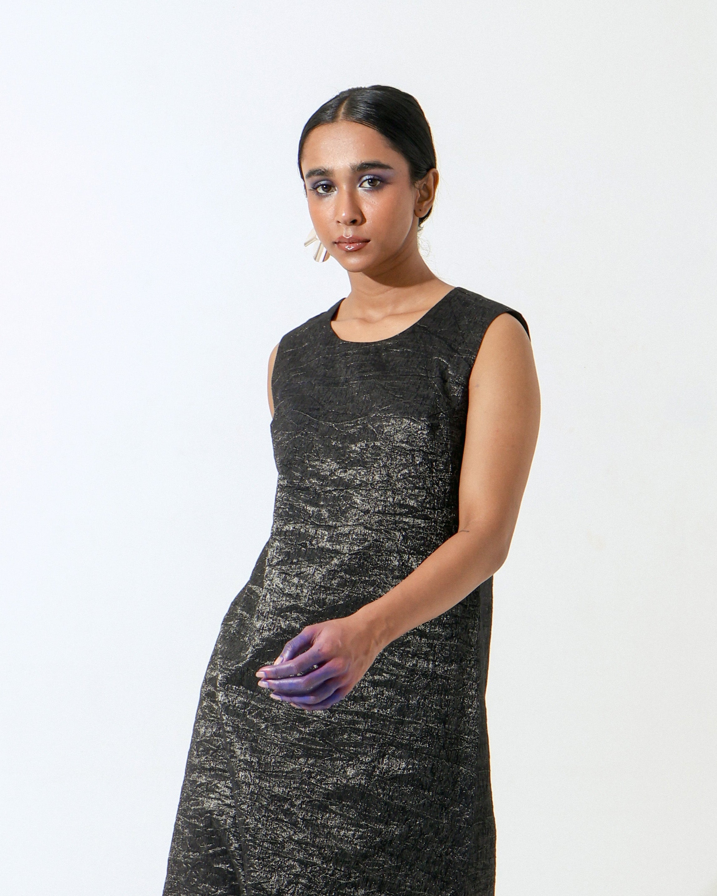 The Shoonyata Burnished Sleeveless Dress is crafted from handwoven silk. .The sleek A-line cut gently skims the body, while the sleeveless design and soft round neckline enhance its modern appeal.