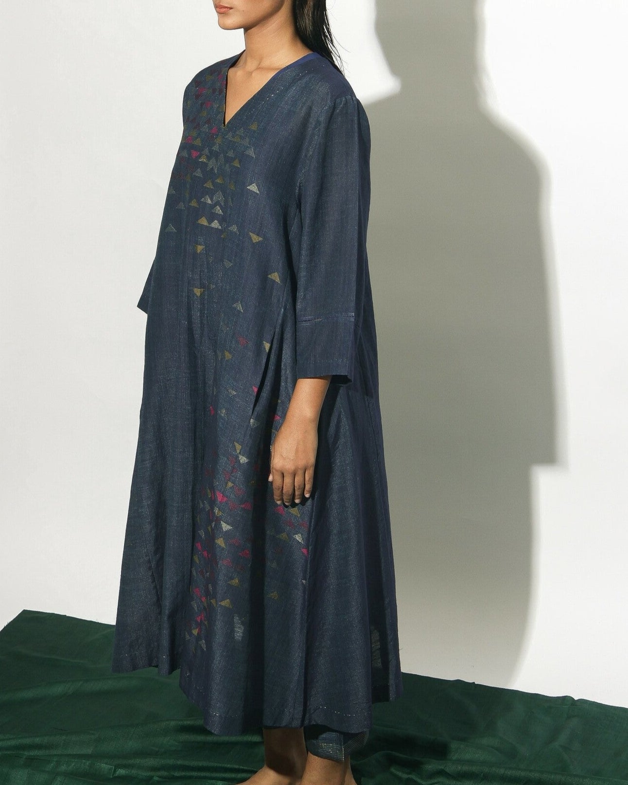 Our silk-cotton V-neck dress with flared side panels features pockets on the inseams and decorative detail on the sleeves. This indigo piece has been crafted from handwoven Jamdani fabri