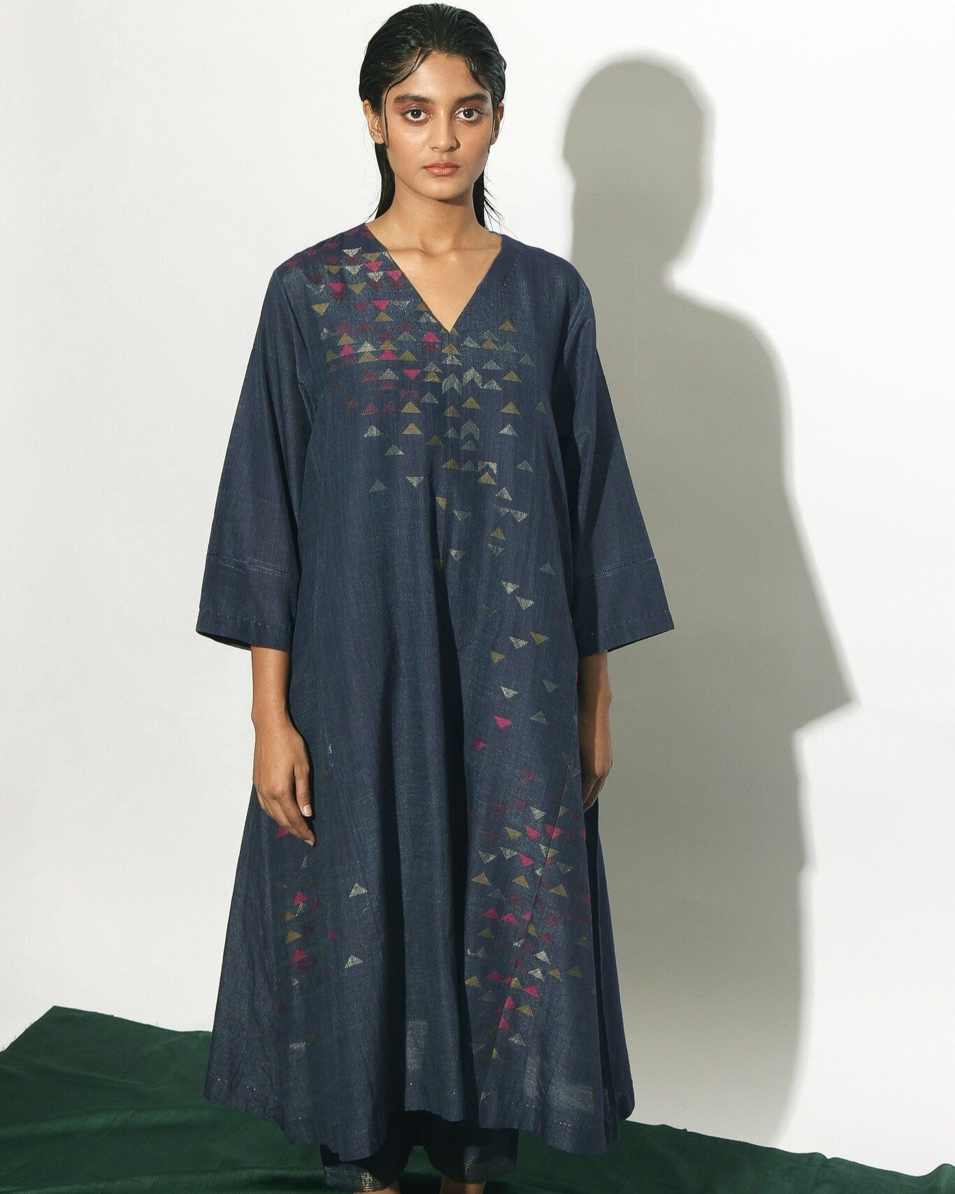 Our silk-cotton V-neck dress with flared side panels features pockets on the inseams and decorative detail on the sleeves. This indigo piece has been crafted from handwoven Jamdani fabri